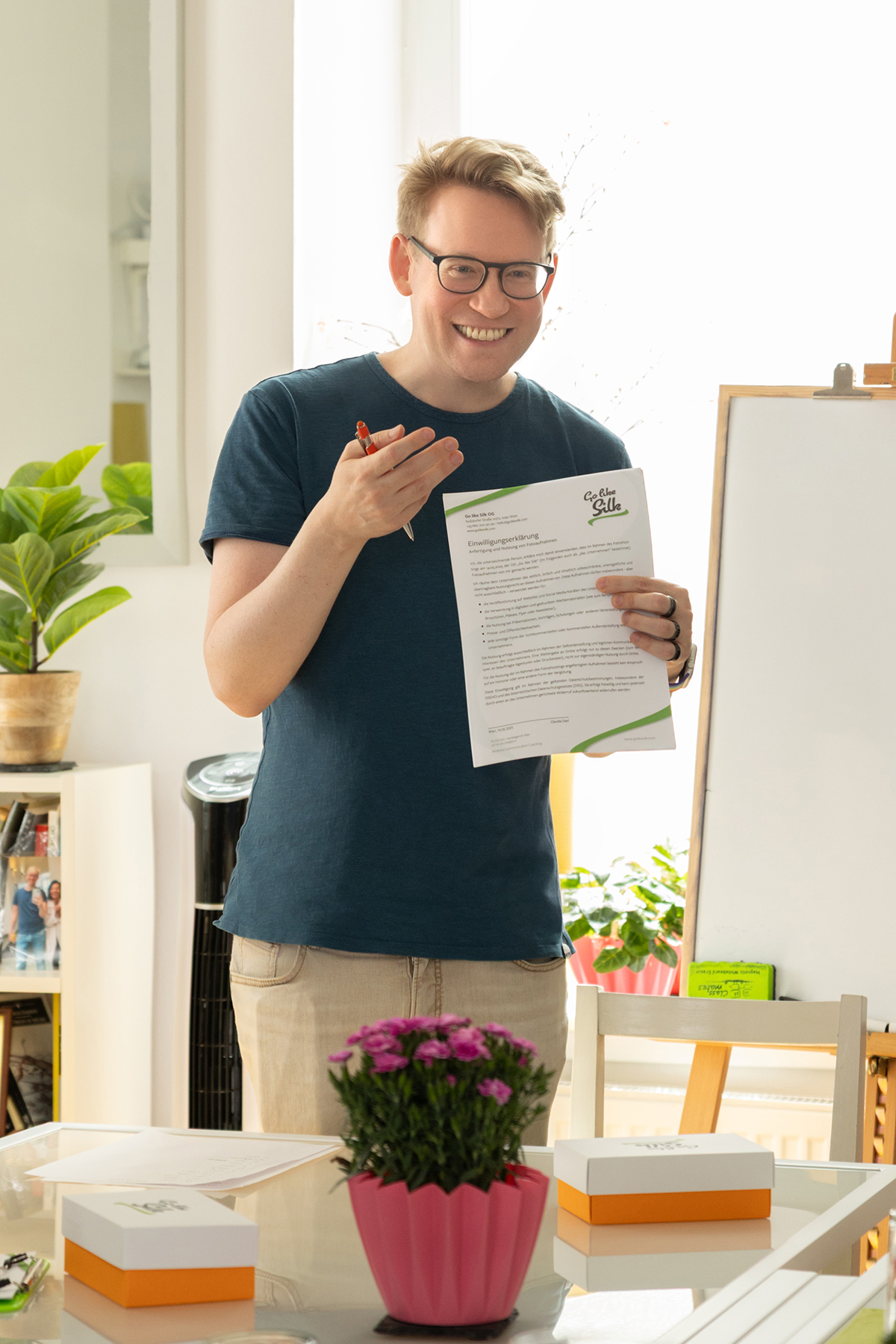 Michael En smiling and holding a piece of paper with writing on it.